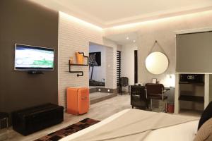 um quarto com uma cama, uma secretária e uma televisão em Stanislas Maison d'hotes em Abidjan