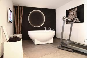 a bathroom with a white bath tub and a treadmill at Stanislas Maison d'hotes in Abidjan