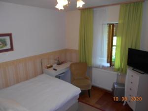 a bedroom with a bed and a desk and a chair at Haus Loidl in Sankt Gallen