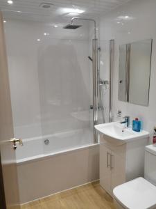 a white bath tub sitting next to a white toilet at Cumberland Hotel in Edinburgh