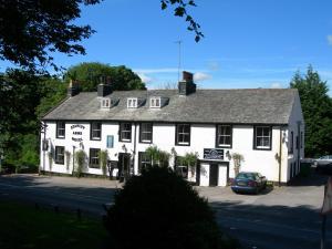 ein weißer Gasthof mit einem Auto davor geparkt in der Unterkunft Stanley Arms Hotel in Seascale