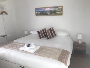 a white bed with a pile of towels on it at Stanley Arms Hotel in Seascale