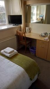 a bedroom with a desk and a bed with a chair at Star Hotel in Kirkcudbright