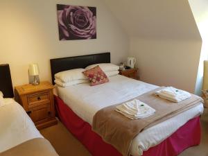 a bedroom with two beds with towels on them at Black Isle Holiday Apartments in Avoch