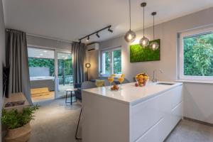 a kitchen with a white island and a living room at Happy Apartments Baška in Baška