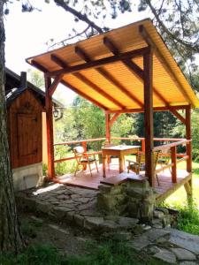 einem Holzpavillon mit einem Picknicktisch und einer Bank in der Unterkunft U Lesíčka in Vysoká