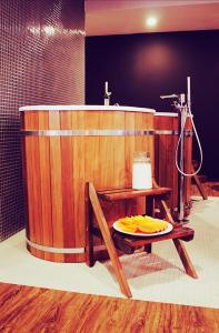 a bathroom with a wooden tub with a plate on a table at Poziom 511 Jura Wellness Hotel & Spa in Ogrodzieniec