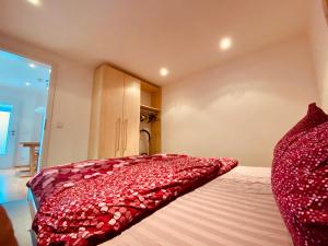 a bedroom with a bed with a red pillow on it at Modernes Apartment am Bodensee in Wasserburg