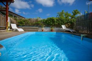 - une grande piscine bleue avec 2 chaises dans la cour dans l'établissement Holiday Home Soleil de Gwada, à Sainte-Anne