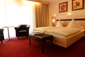 een hotelkamer met een groot bed en een bureau bij Strandhaus an der Mosel in Valwig