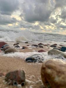 a beach with rocks and the ocean on a cloudy day at Apartaments - Liepu iela in Liepāja