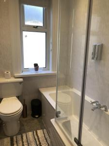 a bathroom with a shower and a toilet and a window at Sapphire House Sasco Apartments in Blackpool