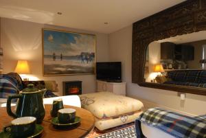 a living room with a bed and a mirror at Garden Studio Spring Cottage in Teffont Magna