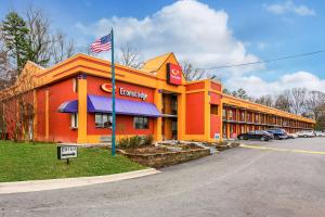 Un edificio arancione con una bandiera americana davanti. di Econo Lodge Charlotte Airport Area a Charlotte