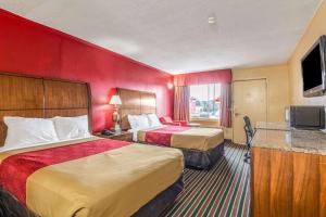 um quarto de hotel com duas camas e uma televisão de ecrã plano em Econo Lodge Charlotte Airport Area em Charlotte