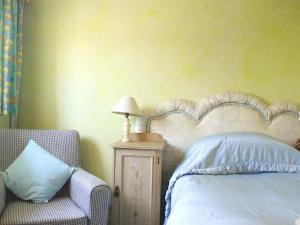 um quarto com uma cama, uma cadeira e um candeeiro em Stone House em Sulgrave