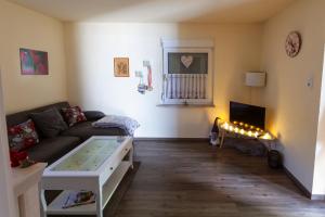 ein Wohnzimmer mit einem Sofa und einem Tisch in der Unterkunft Ferienwohnung Emmi in Bad Neuenahr-Ahrweiler