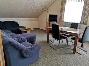 ein Wohnzimmer mit einem Sofa und einem Tisch in der Unterkunft Pension Marcus in Bad Gögging