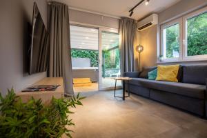 a living room with a blue couch and windows at Happy Apartments Baška in Baška