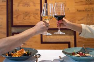 Due persone hanno in mano dei bicchieri di vino. di Hotel Delfino Lugano a Lugano