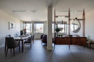 een eetkamer met een tafel en stoelen en een spiegel bij Premiere Apartments Ponte Vecchio in Florence