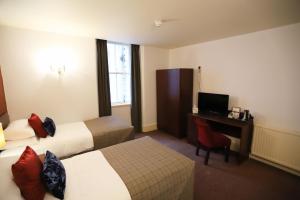 a hotel room with a bed and a television at Ben Wyvis Hotel in Strathpeffer