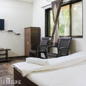 a room with chairs and a bed and a desk at Orchid Anant Holidays in Alibaug