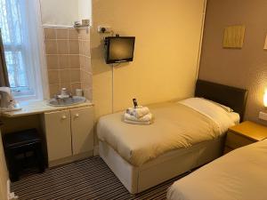 1 dormitorio pequeño con 2 camas y lavamanos en Grange House Hotel, en Blackpool