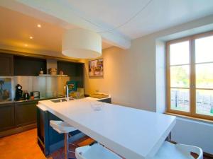 a kitchen with a white counter and some chairs at Les Temps Perdus in Préhy