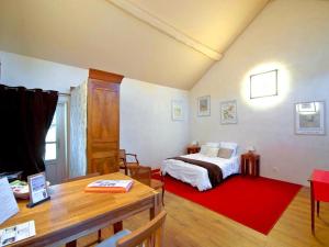 a bedroom with a bed and a red rug at Les Temps Perdus in Préhy
