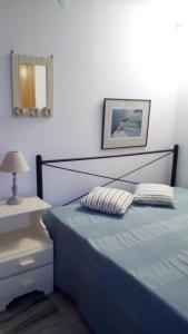 a bedroom with a blue bed and a mirror at panormos studio in Panormos
