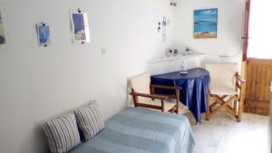 a bedroom with a table and a bed and a table and chairs at panormos studio in Panormos