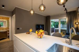 a kitchen with a counter with a bowl of fruit on it at Happy Apartments Baška in Baška