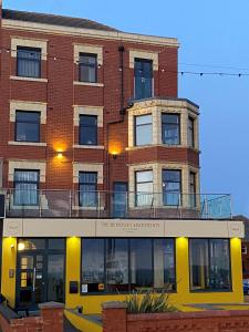 a brick building with a balcony on top of it at Granada Apartments Berkeley in Blackpool