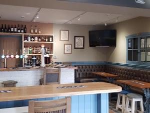 a bar with a wooden table and chairs and a television at The Bowes Hotel in Bardon Mill
