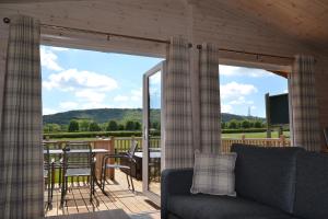 a living room with a couch and a screened in porch at The Chiltern Lodges at Upper Farm Henton in Chinnor