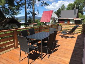 eine Holzterrasse mit einem Tisch und Stühlen darauf in der Unterkunft Chata Bellis in Černá v Pošumaví