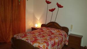 een slaapkamer met een bed met bloemen aan de muur bij Villa Travellito a Martano 13 posti in Martano