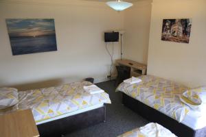 um quarto de hotel com duas camas e uma secretária em Clifton arms em Liverpool