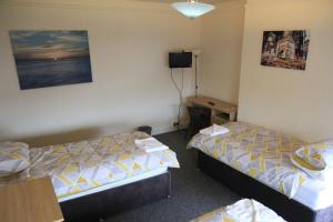 a hotel room with two beds and a desk at Clifton arms in Liverpool