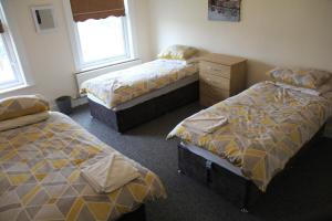 um quarto com 2 camas, uma cómoda e janelas em Clifton arms em Liverpool