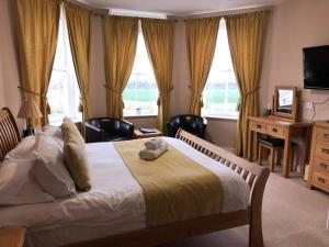 una camera con letto, scrivania e finestre di The Corbet Arms a Shrewsbury