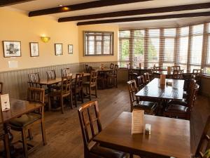 um restaurante com mesas e cadeiras de madeira numa sala em The Corbet Arms em Shrewsbury