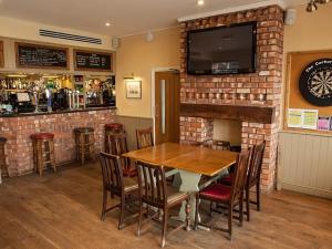 a dining room with a table and a fireplace at The Corbet Arms in Shrewsbury