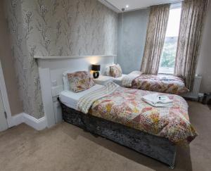 a hotel room with two beds and a window at High Bank Hotel in Leeds +17 photos