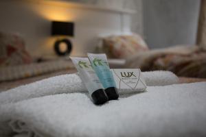 a pile of towels with a tube of toothpaste and a tube of tooth paste at High Bank Hotel in Leeds