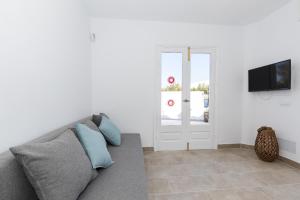 a living room with a couch and a flat screen tv at Chalet a 150m de la playa y piscina privada in Cala'n Bosch