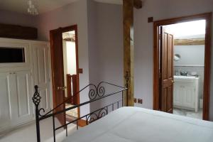 a bedroom with a bed and a hallway with a door at The Dairy at High House in Tintinhull
