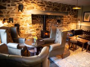 a restaurant with a fireplace and chairs and a table at The Exeter Inn in Bampton