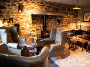 un restaurante con chimenea, sillas y mesa en The Exeter Inn, en Bampton